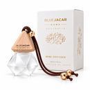 a Blue Jacar Home Mini Diffuser, a clear glass bottle with a wooden top and a brown string hanging from it. The bottle is placed next to its packaging box, which is white and has gold text and graphics on it.
