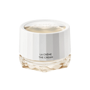 A white jar of La Creme The Cream skincare product against a black background.