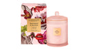 a pink candle and a box of candles with a floral design.