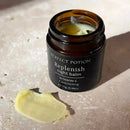 A jar of "Perfection Rephenish Night Balm" with a scoop of the balm on the side, sitting on a light-colored surface.
