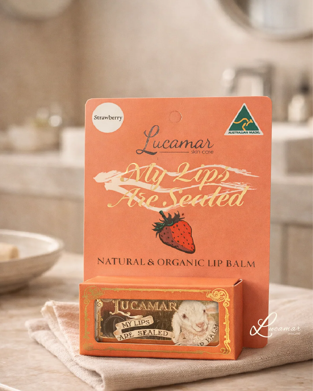 a product called "Lucamar My Lips Are Sealed" lip balm, which is a natural and organic lip balm. The product is displayed on a table, with a towel underneath it.