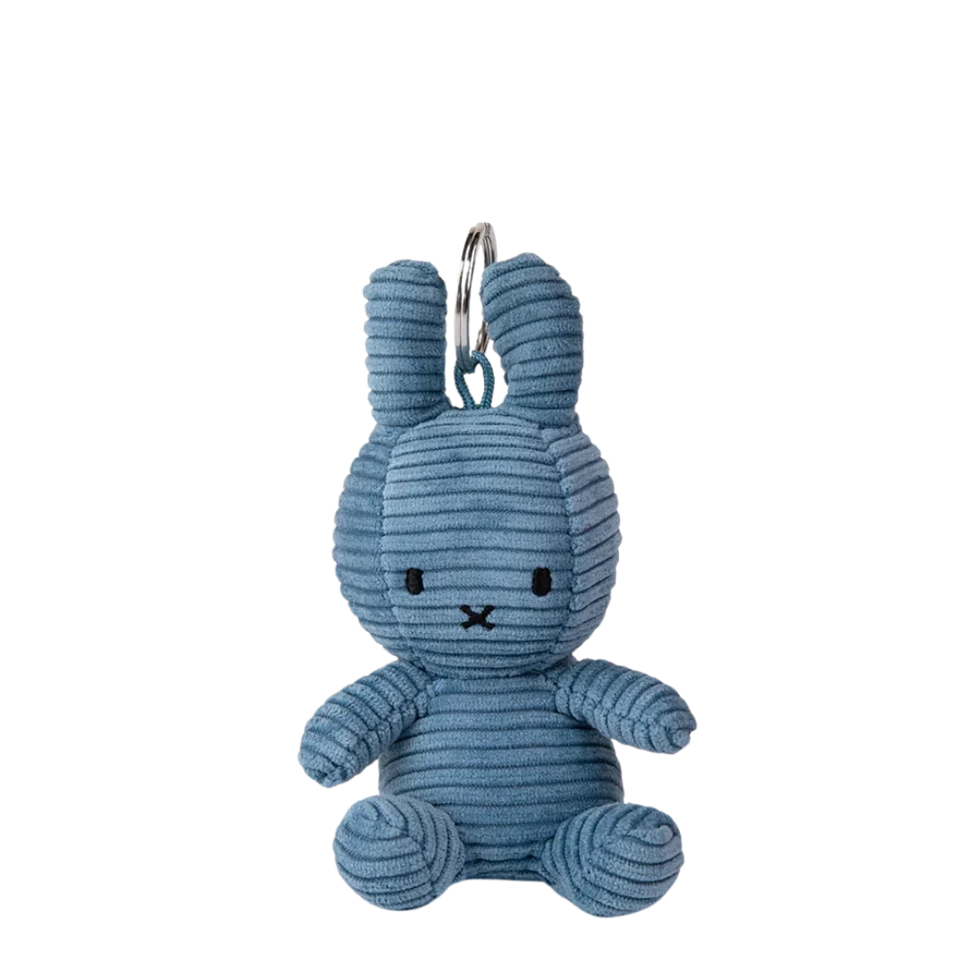 A blue plush rabbit toy is sitting on a black background.