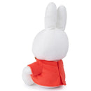 A white plush bunny wearing a red jacket.