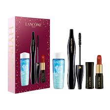 a collection of beauty products from the Lancome brand, including a makeup set, a mascara, a lipstick, and a mascara remover.