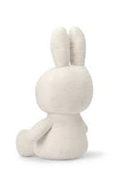 A white stuffed bunny toy sitting upright with its ears perked up.