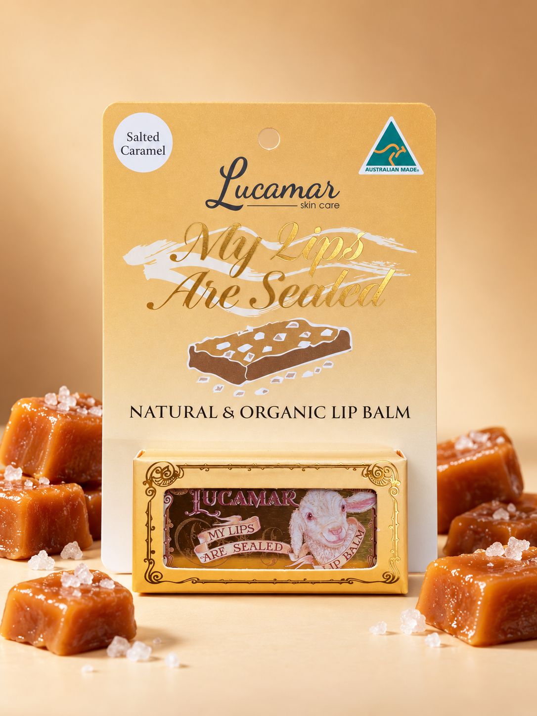 a product called "My Lips Are Sealed" by Lucamar, a natural and organic lip balm. The product is displayed on a table with a small box of the lip balm and several pieces of the product, likely a type of candy or confection.