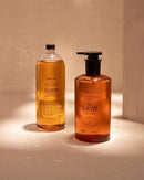 Two bottles of liquid soap, one with a pump dispenser and one with a regular pump, are standing next to each other against a white background.