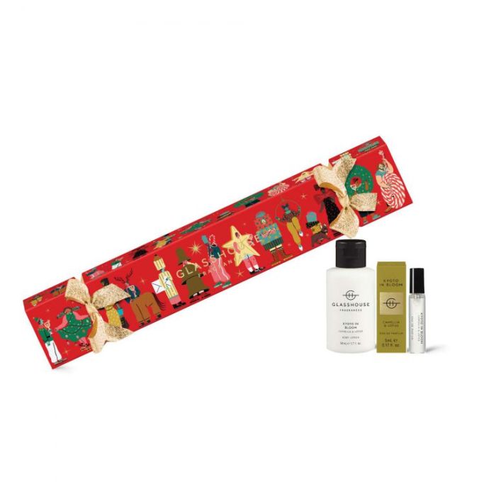 A red gift box with a Christmas-themed illustration, a bottle of "Glosshouse" perfume, and a small bottle of "Glosshouse" body lotion.