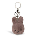 A keychain in the shape of a small, furry bunny with a round head and two black eyes.