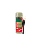 A cylindrical glass jar with a gold lid, containing black incense sticks, and a label that reads "GLASSHOUSE" and "NIGHT BEFORE CHRISTMAS"