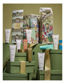 a collection of various skincare and beauty products, including tubes, jars, and bottles, arranged on a green surface. The products appear to be part of a gift set or a display, with some of them placed on top of green boxes. The image does not contain any text, and the focus is on the visual presentation of the products.