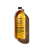 A bottle of Le Savon soap with a yellow liquid inside, placed against a black background.