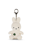 A white stuffed bunny toy with a green clover on its chest, hanging from a silver metal clip.