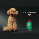 A small, fluffy poodle wearing a red collar sits on a black stand, with a green bottle of Fédé perfume next to it.