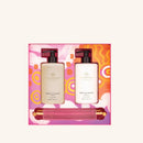 two bottles of Glasshouse fragrances, each with a pump dispenser, placed in a pink and orange box with a floral pattern.
