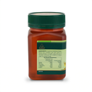 a bottle of honey with a green cap, containing a red liquid.