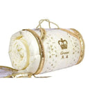 A white and gold rolled-up bedding item with a crown logo on it, placed on a white surface.