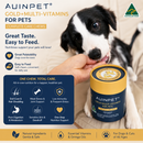 a black and white dog with its head on a hand, holding a cylindrical container of pet food. The container is labeled "Auipet Gold+Multi-Vitamins for Pets" and is described as a "Complete Care Chew" that provides essential vitamins and minerals for dogs.