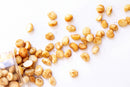a variety of nuts, including macadamia nuts, scattered on a white background.