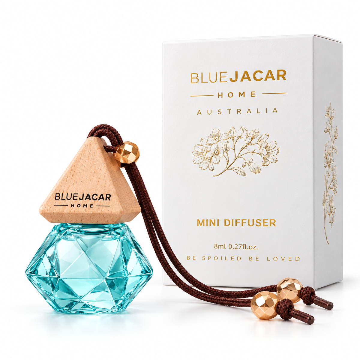 a Blue Jacar Home Mini Diffuser, a blue glass bottle with a wooden top, and a white box with gold text and graphics.