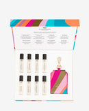 a set of eight perfume bottles arranged in a box, with a colorful lid and a keychain-shaped tag.