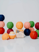 a collection of colorful lip balm tubes arranged on a white background.