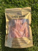 A package of raw meat, specifically chicken maw, laid on the grass.
