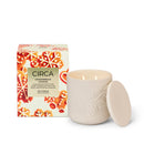 a white ceramic candle in a white ceramic container with a lid, placed next to its packaging box.
