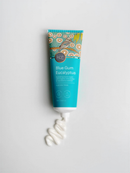 A tube of Blue Gum Eucalyptus Hand & Body Butter with organic shea butter and macadamilla oil, with a bird illustration on the label.