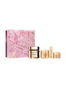 a collection of beauty products, including a pink box with a gold illustration, a gold jar, and four gold bottles, all of which are labeled "LANCÔME".