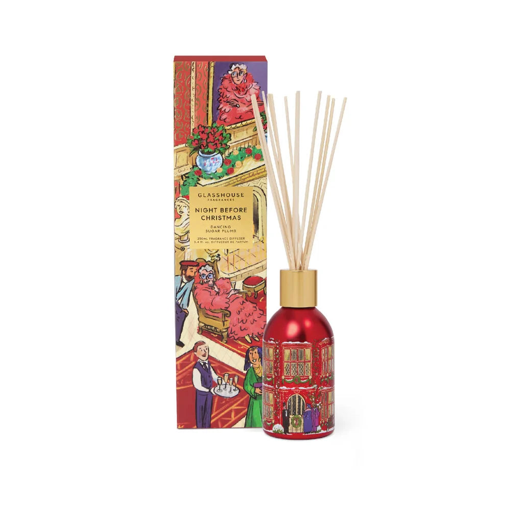 A red diffuser with a gold cap and a box with a colorful illustration of a scene, including a person, a building, and a vase, are displayed against a white background.
