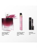 three beauty products: a perfume bottle, a makeup brush, and a mascara tube.