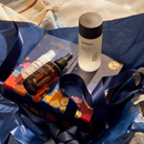 A collection of beauty products, including a bottle of Jurlique, a bottle of Jurlique, and a small bottle, are arranged on a blue background with a floral pattern.