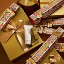 a collection of golden gift boxes and packages adorned with festive designs, including Christmas-themed patterns and ribbons.