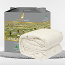 a gray cardboard box with a picture of a herd of sheep on it, and a white blanket folded on top of the box.