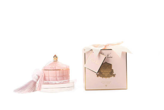 A pink perfume bottle with a tassel and a pink box with a gold label are shown against a white background.