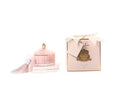 A pink perfume bottle with a tassel and a pink box with a gold label are shown against a white background.