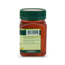 a bottle of honey with a green cap, featuring a label with text and a barcode.