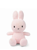 A pink stuffed bunny toy with large ears and a small black nose.
