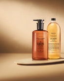 Two bottles of hand soap are displayed against a beige background.