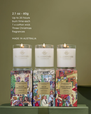 Three candles from the brand Glasshouse, each with different scents, are displayed on a table.