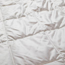 a close-up view of a white, wrinkled fabric, possibly a blanket or quilt.