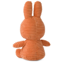 An orange plush bunny toy sitting upright and facing away from the camera.