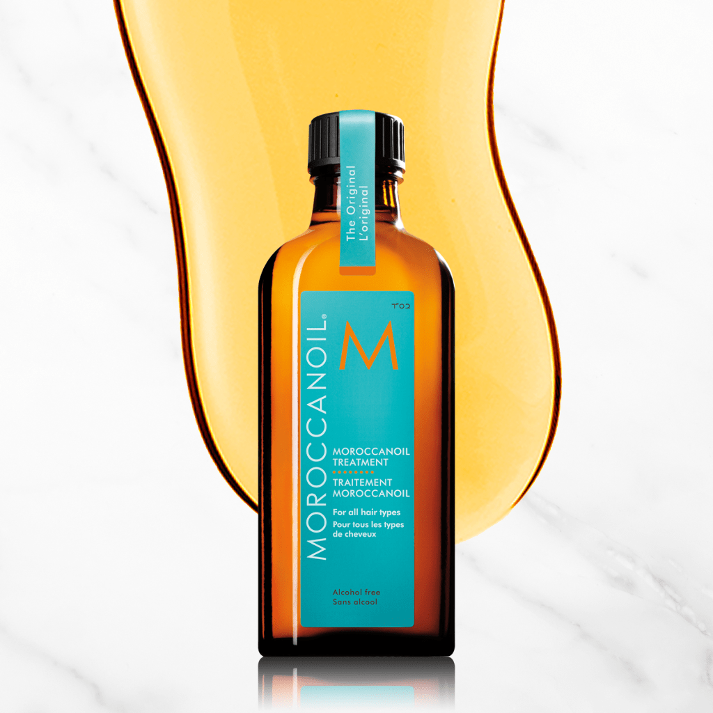 A bottle of Moroccan oil against a marble background.