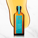 A bottle of Moroccan oil against a marble background.