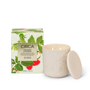 a white ceramic candle with a lid and a box with a raspberry and rhubarb design, both placed on a white background.