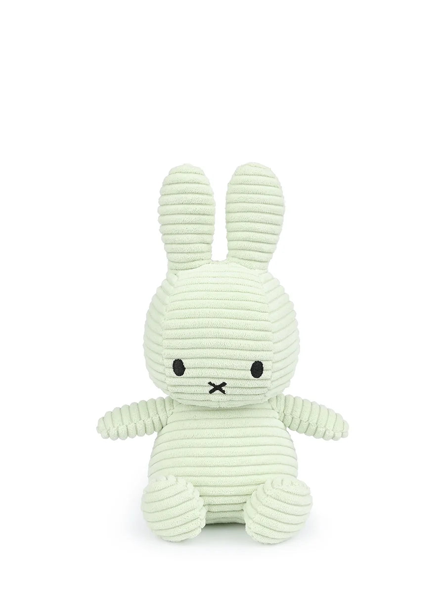 A light green plush bunny toy with black eyes and mouth.