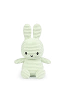A light green plush bunny toy with black eyes and mouth.