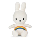 A white plush toy rabbit with a rainbow patch on its belly.