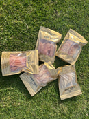 five packages of dried meat, specifically Ling Maw, arranged on a grassy surface.
